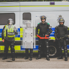 Five Op Shield officers in front of police van with riot shields, big red key and full gear