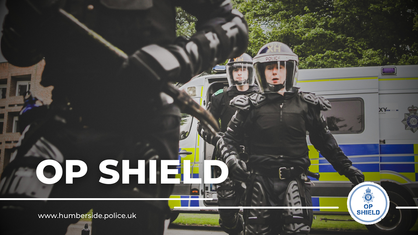 Close up of Op Shield officers in full gear running towards property with text saying 'Op Shield'