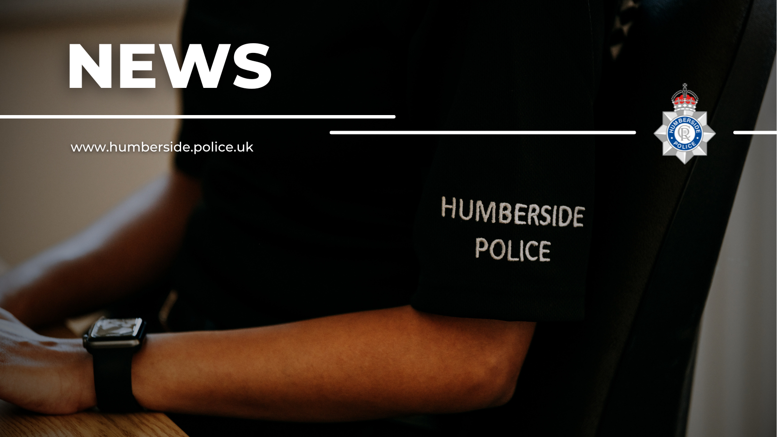 Close up of police officer at a computer with the text News overlayed