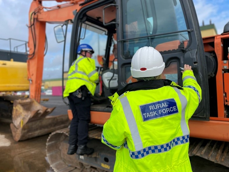Photo showing Rural Task Force officers looking in digger machinery