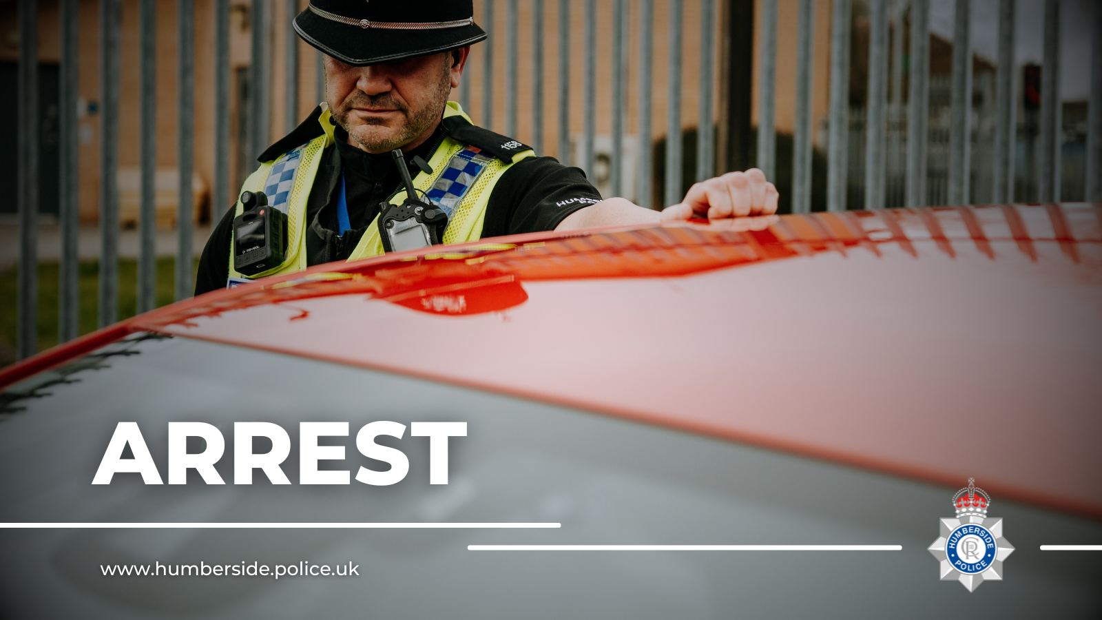 Image of officer standing by the side of a car